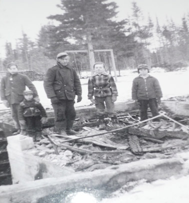 Standing in what is left of our home:  Terrence Walls with his hand on Eric Underhill’s shoulder, Jim MacKenzie, Michael McLaughlin, and Dale MacKenzie.  You can see our swing tree in the back yard, and a pile of firewood by the back fence.