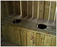 The side-by-side holes inside a typical ‘two-holer’ outhouse