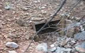 A culvert opening under the road, similar to the one we crawled through!