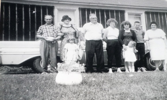 Dad, Granny, Grampa, Mom, Aunt Greta, me, and Aunt Patricia.  The two little girls in front are my little sister Leslie, and Aunt Greta’s daughter, Colleen.  Note the chamber pot that Dad’s holding in his hands.  He went and got the pot to pose with before the picture was taken.  And Granny laughed and laughed!