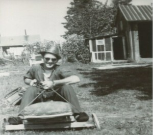 Uncle Gordon having a good laugh, sitting with his briefcase on the go-card I made. In the background is the shed that Dad built, with the attached play house