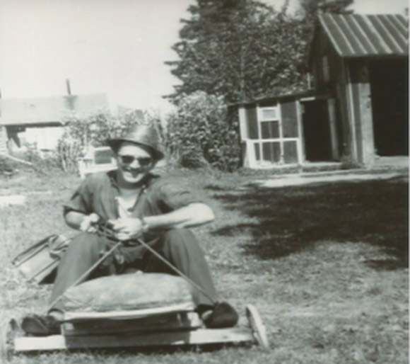 Uncle Gordon having a good laugh, sitting with his briefcase on the go-card I made.   In the background is the shed that Dad built, with the attached play house