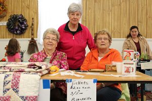 Margaret Mountain, Carrie Weaver and Lillian Brennan of the Blackville Women's Institute selling tickets on quilts